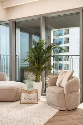 a living room with two chairs and a plant at Seraya Residence 9 - 4BDR - Skyline and Burj View - 3 Balconies in Dubai