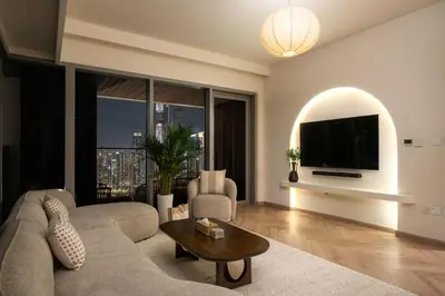 a living room with a couch and a flat screen tv at Seraya Residence 9 - 4BDR - Skyline and Burj View - 3 Balconies in Dubai