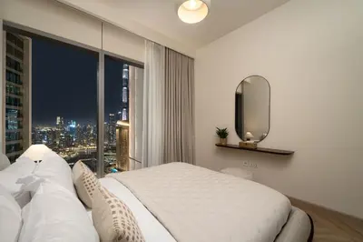 a bedroom with a bed and a large window at Seraya Residence 9 - 4BDR - Skyline and Burj View - 3 Balconies in Dubai