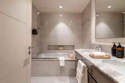 a bathroom with a tub and a sink at Seraya Residences at Forte in Dubai