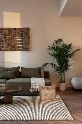 a living room with a green couch and a table at Seraya Residences at Forte in Dubai