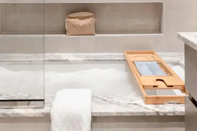 a bathroom with a bath tub with a sink at Seraya Residences at Forte in Dubai