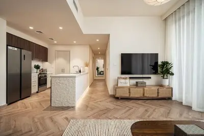 a kitchen with a large tv on a wall at Seraya Residences at Forte in Dubai