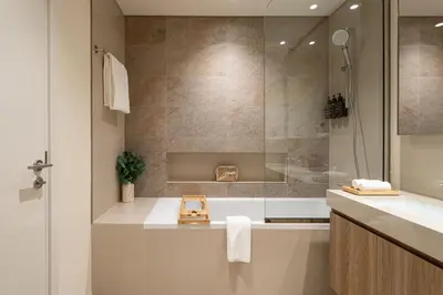 a bathroom with a shower and a tub and a sink at Seraya Residences at Downtown Views 2 in Dubai