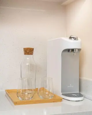 two wine glasses and a blender on a cutting board at Seraya Residences at Downtown Views 2 in Dubai