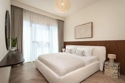 a bedroom with a white bed and a large window at Seraya Residence 11 - 3BDR - Private Jacuzzi and Infrared Sauna in Dubai