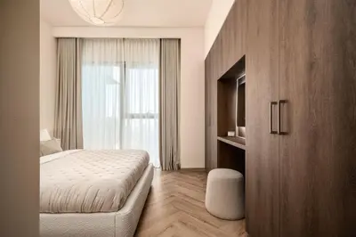 a bedroom with a bed and a large window at Seraya Residence 11 - 3BDR - Private Jacuzzi and Infrared Sauna in Dubai