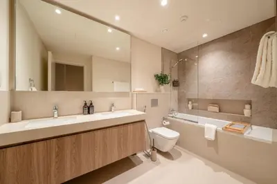 a bathroom with a sink and a toilet and a mirror at Seraya Residence 11 - 3BDR - Private Jacuzzi and Infrared Sauna in Dubai