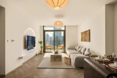 a living room with a couch and a tv at Seraya Residences at Burj Crown in Dubai