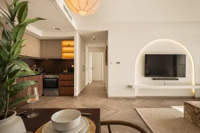 a living room with a kitchen with a large television at Seraya Residences at Burj Crown in Dubai