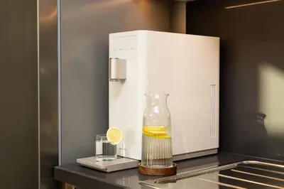a glass vase with a drink and a lemon on a counter at Seraya Residences at Burj Crown in Dubai