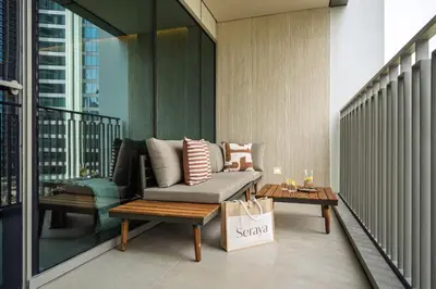 a balcony with a couch and a coffee table at Seraya Residence 14 - 4 BDR - Burj Views - Big Balcony in Dubai