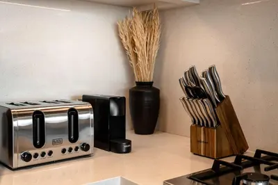 a kitchen counter with a toaster and a vase with some knives at Seraya Residence 14 - 4 BDR - Burj Views - Big Balcony in Dubai