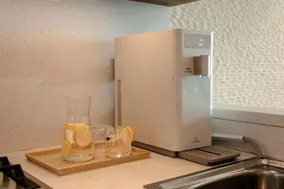 a kitchen counter with a juicer and two glasses of juice at Seraya Residence 14 - 4 BDR - Burj Views - Big Balcony in Dubai