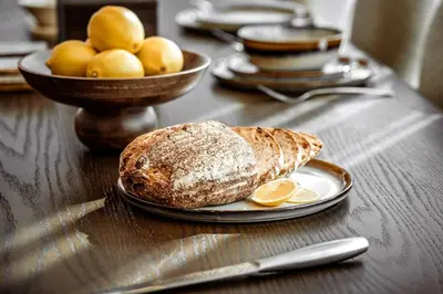 a table with a plate of bread and a bowl of fruit at Seraya Residence 15 - 3BDR - Burj View and Dubai Mall access in Dubai
