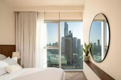 a bedroom with a large window and a mirror at Seraya Residence 15 - 3BDR - Burj View and Dubai Mall access in Dubai