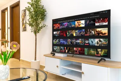 a television on a stand in a living room at New Contemporary Lux and Pool & Kids Amenities in JVC in Dubai