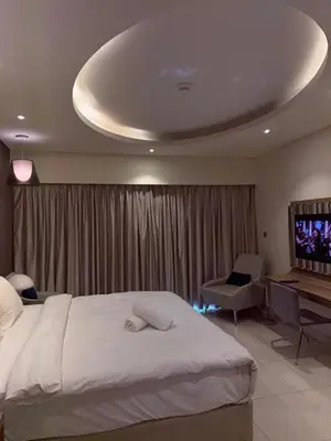 a bedroom with a bed and a desk and a television at Royal Montania by DAMAC Paramount , Burj Khalifa View in Dubai