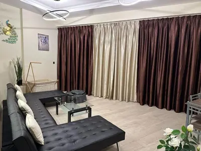 a living room with a black couch and curtains at Dubai Skyline & Creek View - Homeyvillas in Dubai