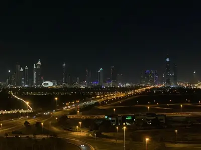a city at night with street lights and buildings at Dubai Skyline & Creek View - Homeyvillas in Dubai