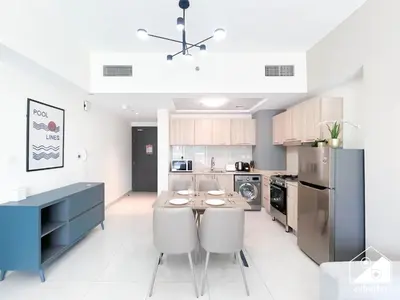 a kitchen with a table and chairs and a refrigerator at Amazing Stay in AG Tower , Business bay in Dubai