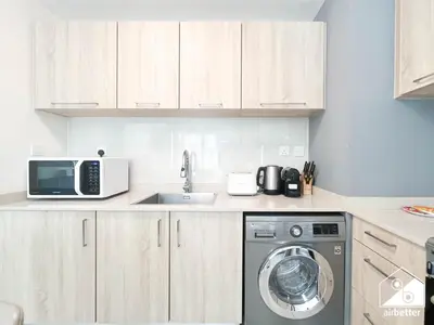 a kitchen with a washing machine and a microwave at Amazing Stay in AG Tower , Business bay in Dubai