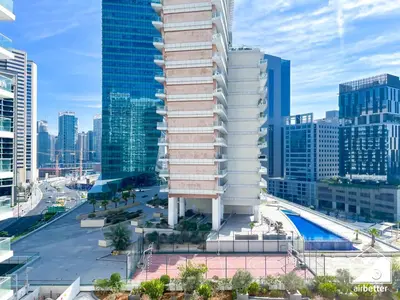 a tall building with a pool in front of a city at Amazing Stay in AG Tower , Business bay in Dubai