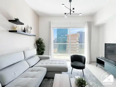 a living room with a white couch and a television at Luxury At AG Tower Business Bay & City Views in Dubai
