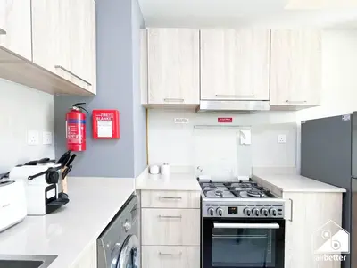 a kitchen with white cabinets and a stove top oven at Luxury At AG Tower Business Bay & City Views in Dubai