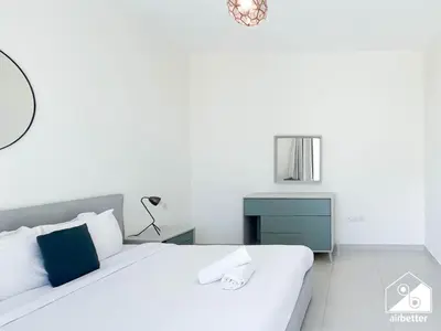a bedroom with a white bed and a blue cabinet at Luxury At AG Tower Business Bay & City Views in Dubai