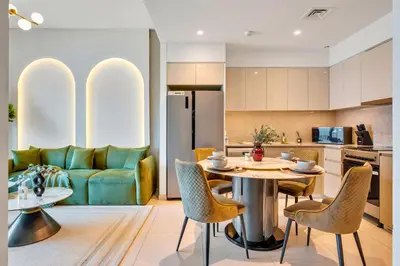 a kitchen and living room with a table and chairs at Skyline Gem Full Burj View 2BR Suite with Dubai Mall access by Maxx Value homes in Dubai
