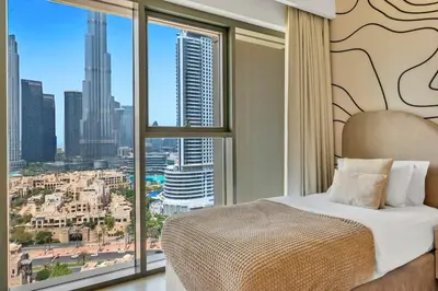 a bedroom with a bed and a large window at Skyline Gem Full Burj View 2BR Suite with Dubai Mall access by Maxx Value homes in Dubai