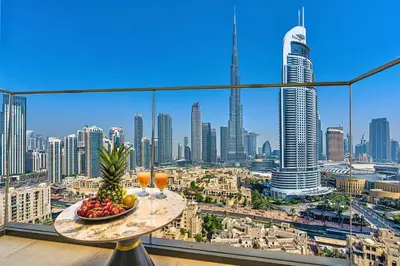 a table with a bowl of fruit on top of a city skyline at Skyline Gem Full Burj View 2BR Suite with Dubai Mall access by Maxx Value homes in Dubai