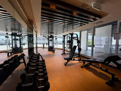 a gym with several tread machines in a room with windows at Dubai Studio Retreat Pool, Gym, Balcony & Queen Bed for Two in Dubai