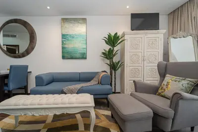 a living room with blue couches and a tv at Luxury Living in Matrix Tower Near Sports City in Dubai