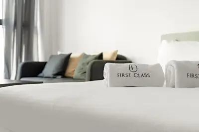 a white bed with first class pillows and a couch at Business Bay Studio Near Dubai Mall, Burj Khalifa & Downtown Hotspots in Dubai