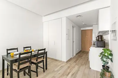a dining room with a table and chairs and a kitchen at Business Bay Studio Near Dubai Mall, Burj Khalifa & Downtown Hotspots in Dubai