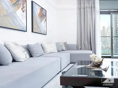 a white living room with a couch and a table at Luxurious 2BR in Burj Crown with Burj Khalifa View in Dubai