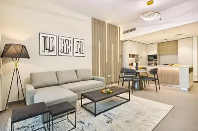 a living room with a couch and a table at Designer Apartments in Kensington Waters, MBR City, with Pool Gym Sauna & Parking near Downtown and Creek in Dubai