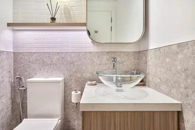 a bathroom with a sink and a toilet and a mirror at Designer Apartments in Kensington Waters, MBR City, with Pool Gym Sauna & Parking near Downtown and Creek in Dubai