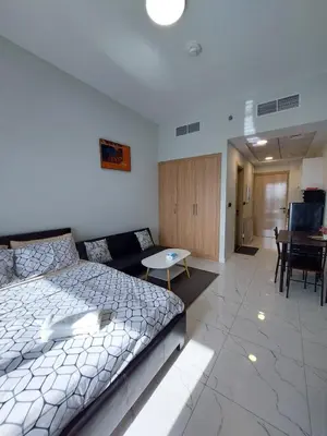 a bedroom with a bed and a couch and a table at Urban Studio - Walk to Metro - Homeyvillas in Dubai