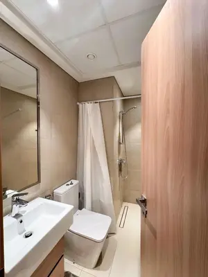 a bathroom with a sink and a toilet and a mirror at COZY 1 BR Apartment in Dubai