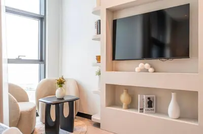 a living room with a television on a wall at Gem in the heart of Business Bay - 15 Northside in Dubai