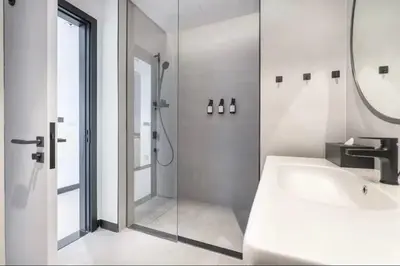 a white bathroom with a shower and a sink at Gem in the heart of Business Bay - 15 Northside in Dubai