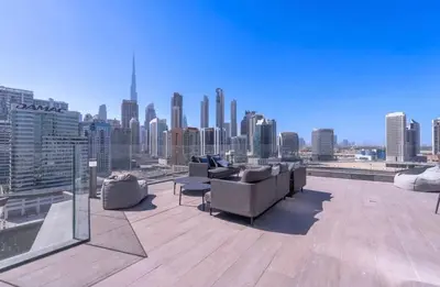 a rooftop with couches and a view of a city at Gem in the heart of Business Bay - 15 Northside in Dubai