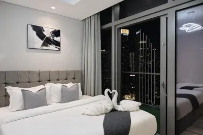 a bedroom with a bed with two swans on it at 2BR Burj Khalifa and Sea View Apartments in Paramount Hotel Midtown in Dubai