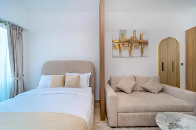 a bedroom with a couch and a bed and a chair at Luxurious Serenity 5-Star Lifestyle in JVC in Dubai