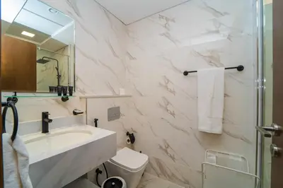 a bathroom with a sink and a toilet and a mirror at Luxurious Serenity 5-Star Lifestyle in JVC in Dubai