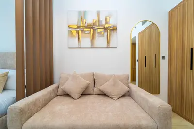 a living room with a couch and a mirror at Luxurious Serenity 5-Star Lifestyle in JVC in Dubai