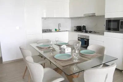 a kitchen with a glass table and white cabinets at Palace Residences luxurious 2 bedroom with breathtaking views in Dubai